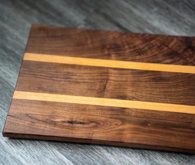 Dark wood cutting board with two light wood inlay stripes
