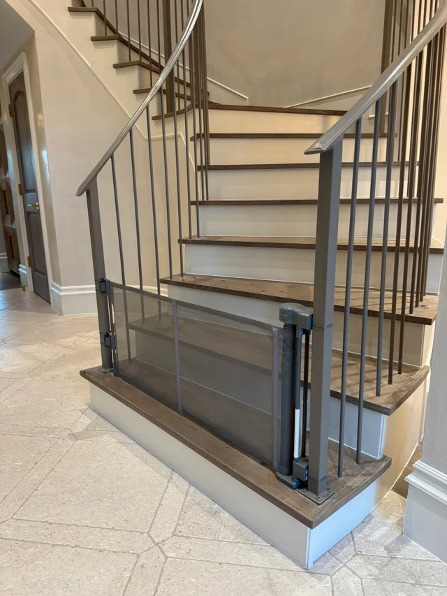 Retractable gate fitted across the bottom of an interior staircase
